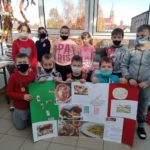 Uczniowie prezentują wykonany przez siebie plakat z propozycjami co warto zjeść we Włoszech.