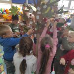 Dzieci ozdabiają tekturowe drzewko