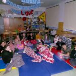 Uczniowie klasy 5a oglądają w film leżąc wygodnie na materacach