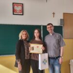 ks. Mariusz Majczak i Pani Ania Korycka (wychowawczyni) przekazują uczennicy klasy 6 C Julii Boczkowskiej nagrodę za zajęcie 1 miejsca w konkursie w kategorii literackiej
